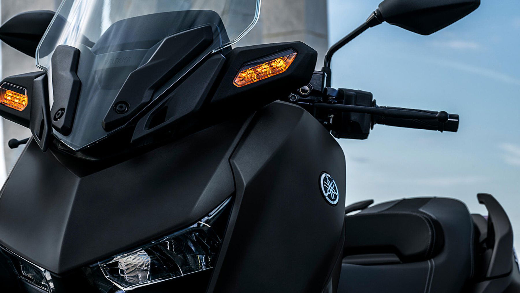 Vista frontal de la Yamaha X-Max 125cc que muestra sus faros y parte del manillar. Vista frontal de la Yamaha X-Max 125cc que muestra sus faros y parte del manillar.