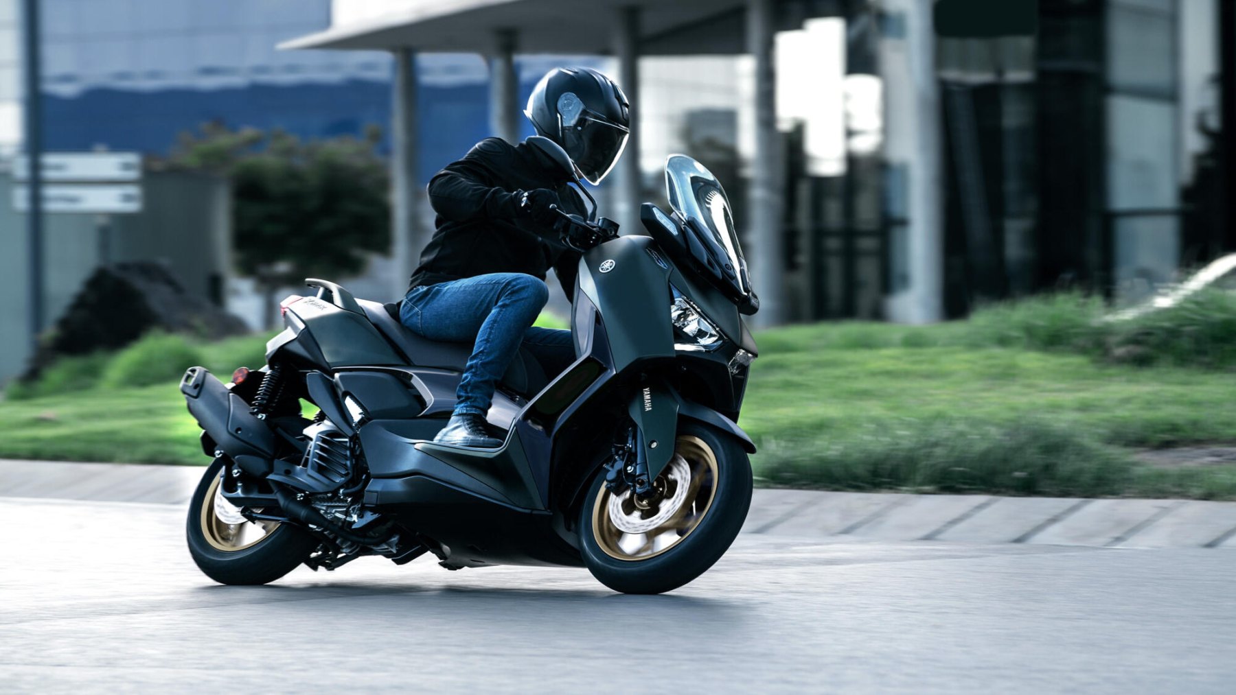 Vista dinámica lateral de la Yamaha X-Max 125cc en movimiento, destacando su diseño deportivo.