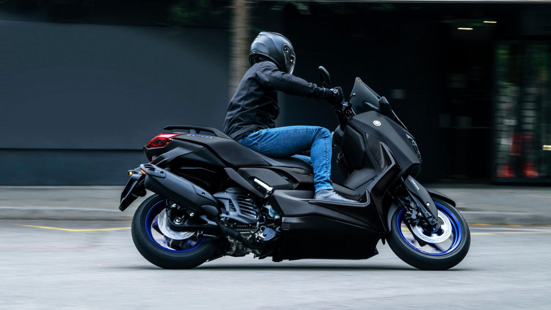 Vista dinámica de la Yamaha X-Max 125cc en movimiento, destacando su diseño aerodinámico. Vista dinámica de la Yamaha X-Max 125cc en movimiento, destacando su diseño aerodinámico.