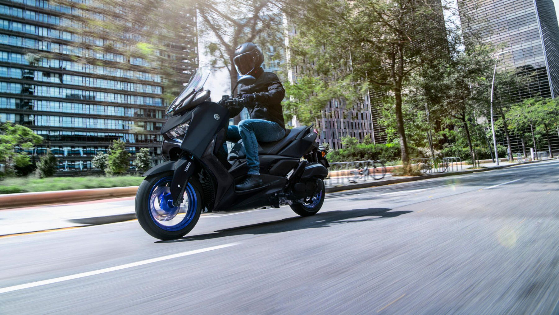Vista dinámica lateral de la Yamaha X-Max 125cc en entorno urbano Vista dinámica lateral de la Yamaha X-Max 125cc en entorno urbano