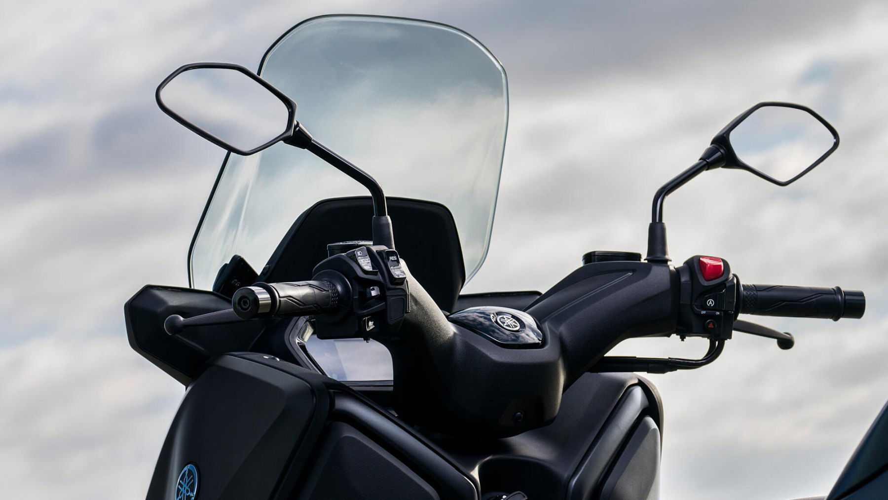 Vista del manillar de la Yamaha X-Max 125cc destacando ergonomía y acabados. Vista del manillar de la Yamaha X-Max 125cc destacando ergonomía y acabados.
