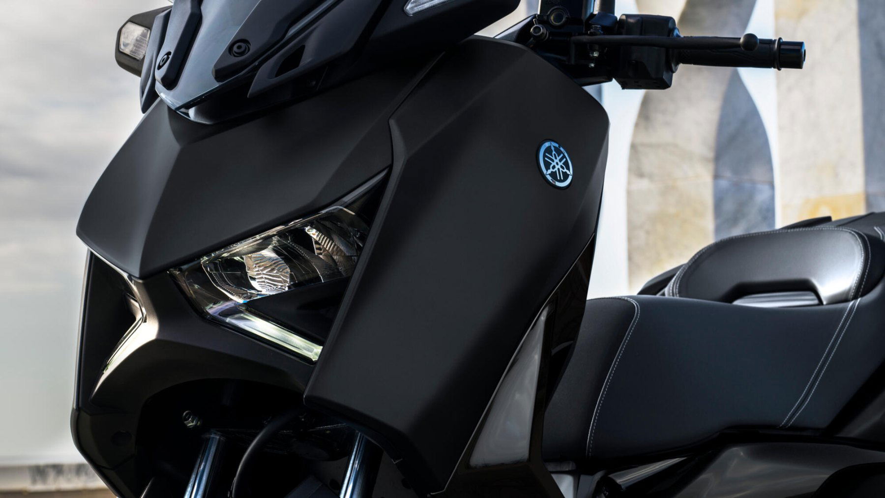 Vista frontal y lateral de la Yamaha X-Max 125cc, destacando su diseño aerodinámico. Vista frontal y lateral de la Yamaha X-Max 125cc, destacando su diseño aerodinámico.