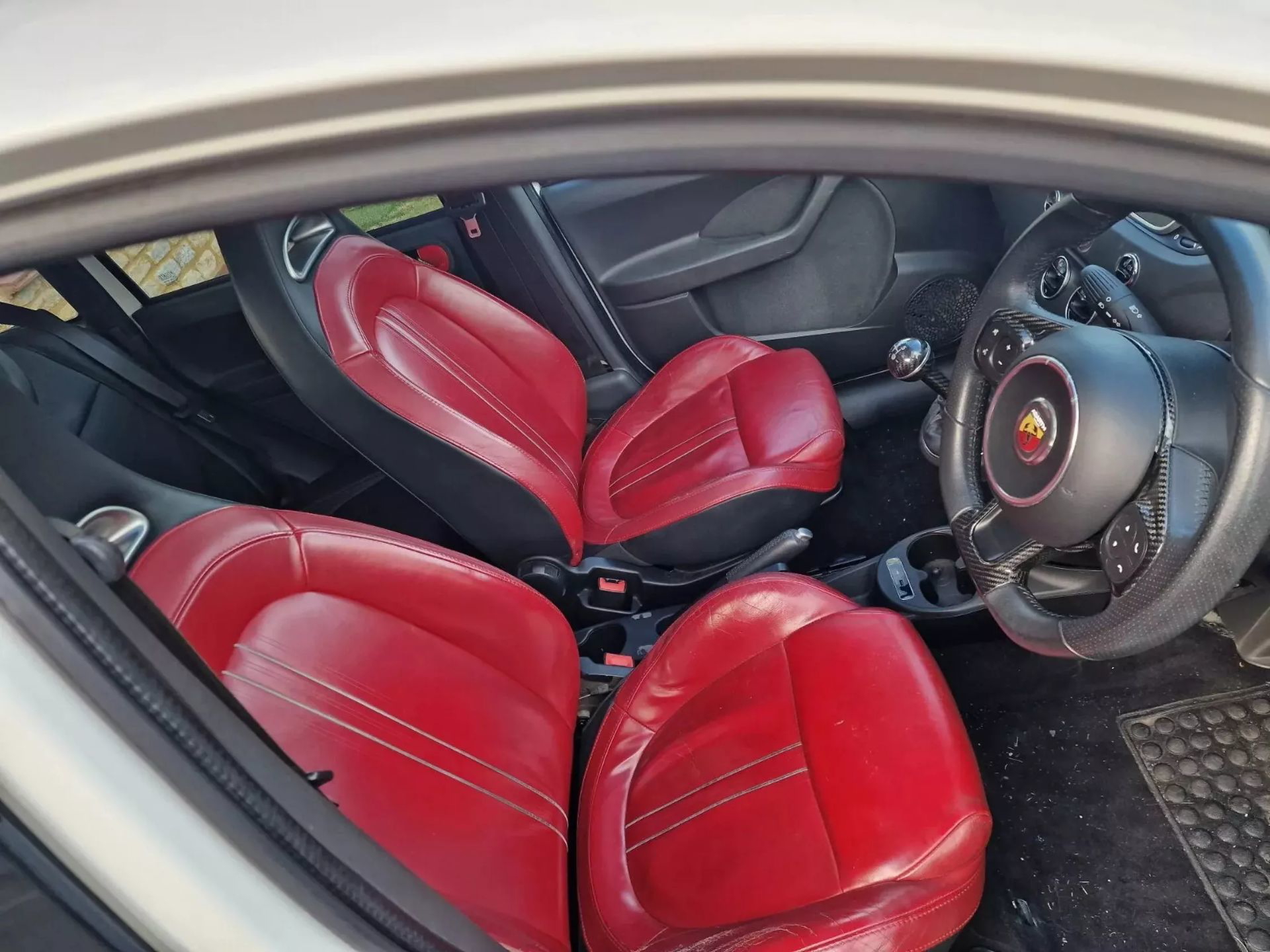 Vista lateral de los asientos deportivos rojos en el interior del Abarth Panda.