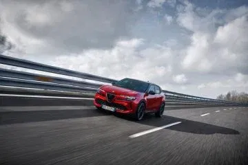Vista dinámica del lado del Alfa Romeo en acción, diseño que evoca deportividad. Vista dinámica del lado del Alfa Romeo en acción, diseño que evoca deportividad.