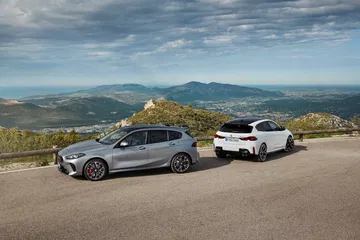 La imagen muestra la cuarta generación del BMW Serie 1 en un entorno natural, destacando su diseño lateral.