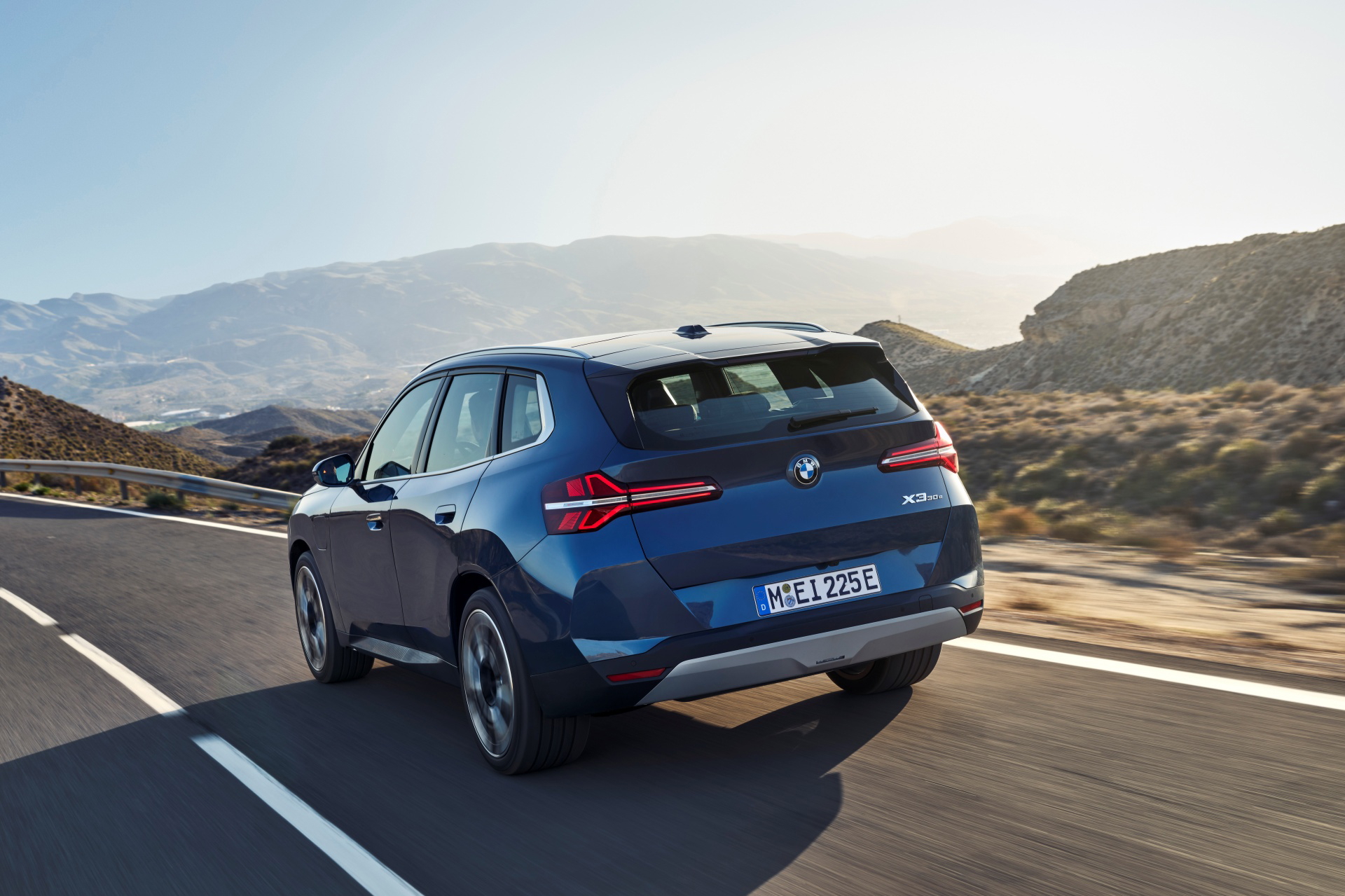Vista lateral del BMW X3 30e xDrive en movimiento, reflejando elegancia y dinamismo.