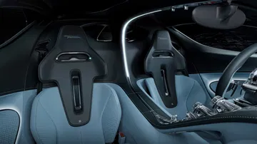Cabina de lujo del Bugatti Tourbillon con asientos de cuero azul y volante detallado. Cabina de lujo del Bugatti Tourbillon con asientos de cuero azul y volante detallado.