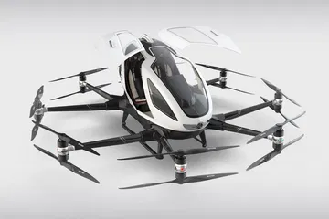Taxi volador EHang autónomo con puertas abiertas, listo para revolucionar el transporte urbano.