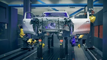 Lado del Ford EV Crossover en la línea de producción, ambiente industrial.