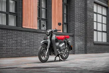 Honda Super Cub 125 en su hábitat urbano, mezcla de economía y estilo clásico.