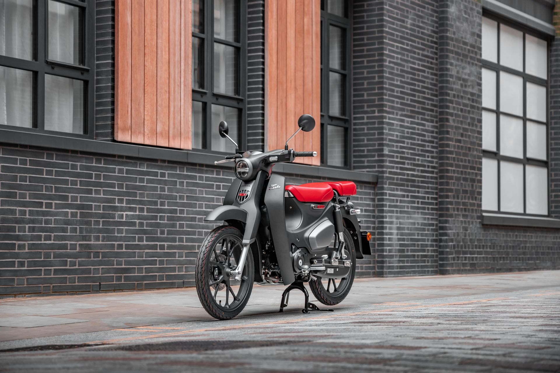 Honda Super Cub 125 en su hábitat urbano, mezcla de economía y estilo clásico.