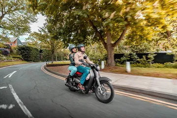 Honda Super Cub 125 en acción, ícono de eficiencia y economía.