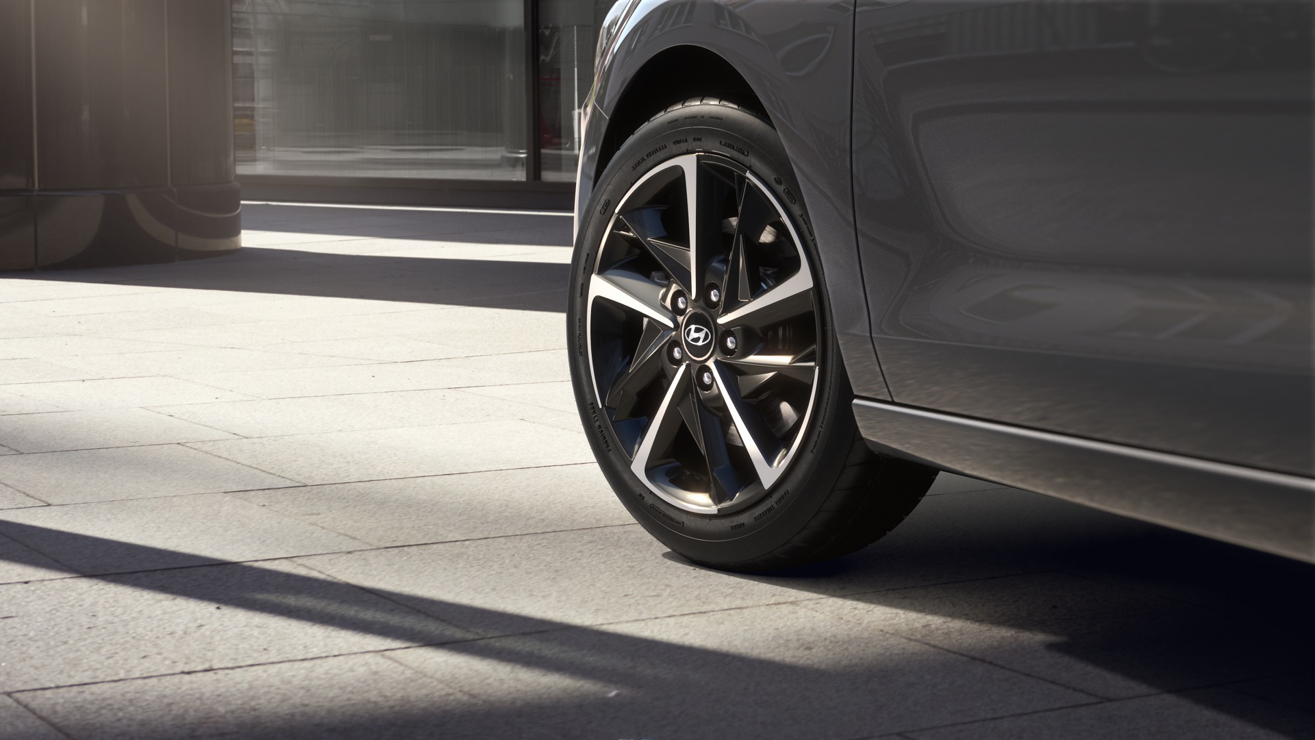 Vista lateral del Hyundai i30 Fastback 2024 mostrando el diseño de las llantas y la silueta del vehículo.
