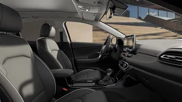 Vista lateral delantera de la cabina del Hyundai i30 Wagon 2024, diseño moderno y ergonómico.