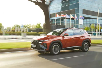 Hyundai Tucson en movimiento, destacando su diseño lateral y dinamismo.