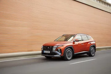 Vista dinámica del Hyundai Tucson 2024 en movimiento, destacando su línea lateral.