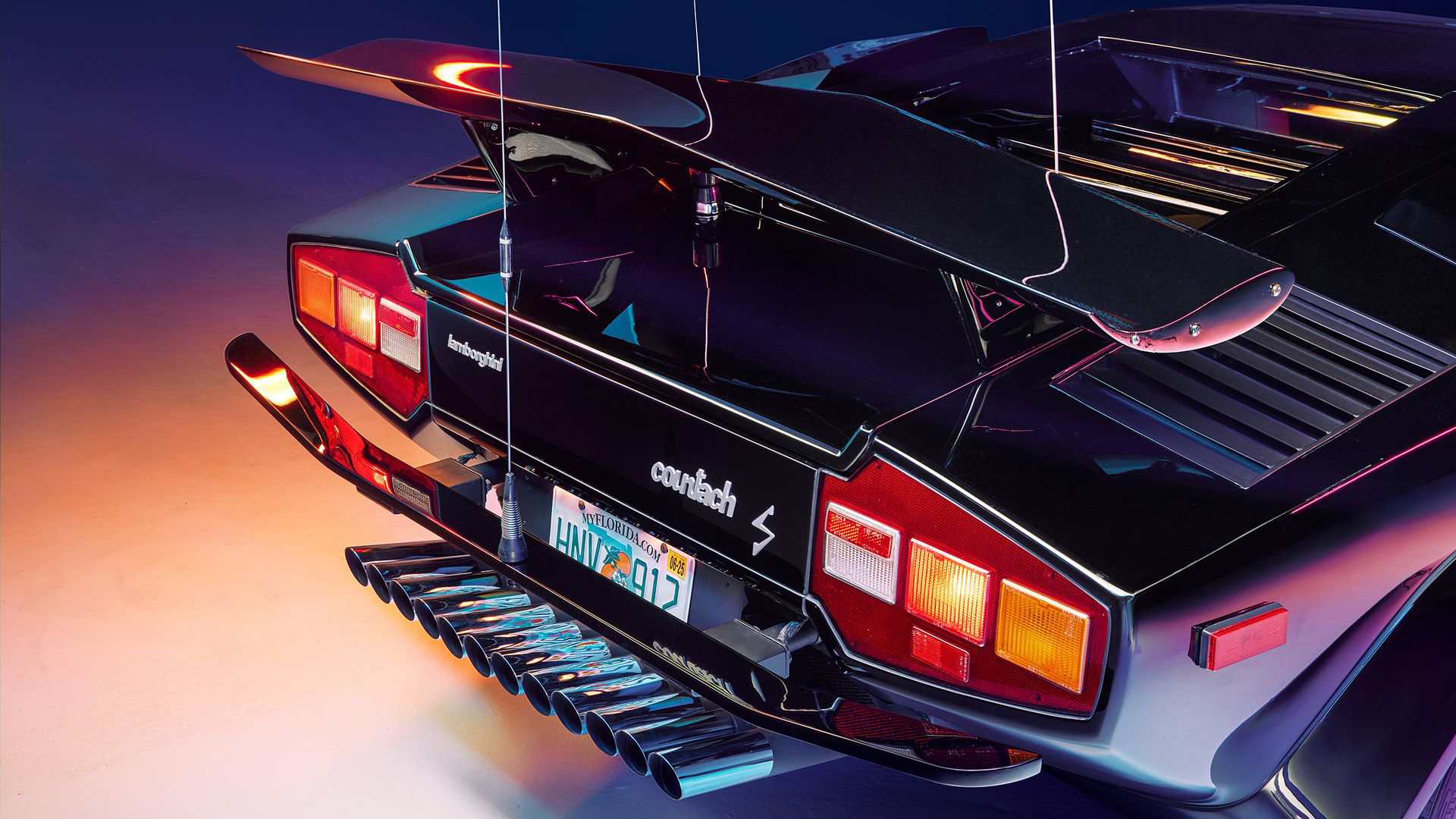 Vista trasera Lamborghini Countach con doce tubos escape y dos alerones.