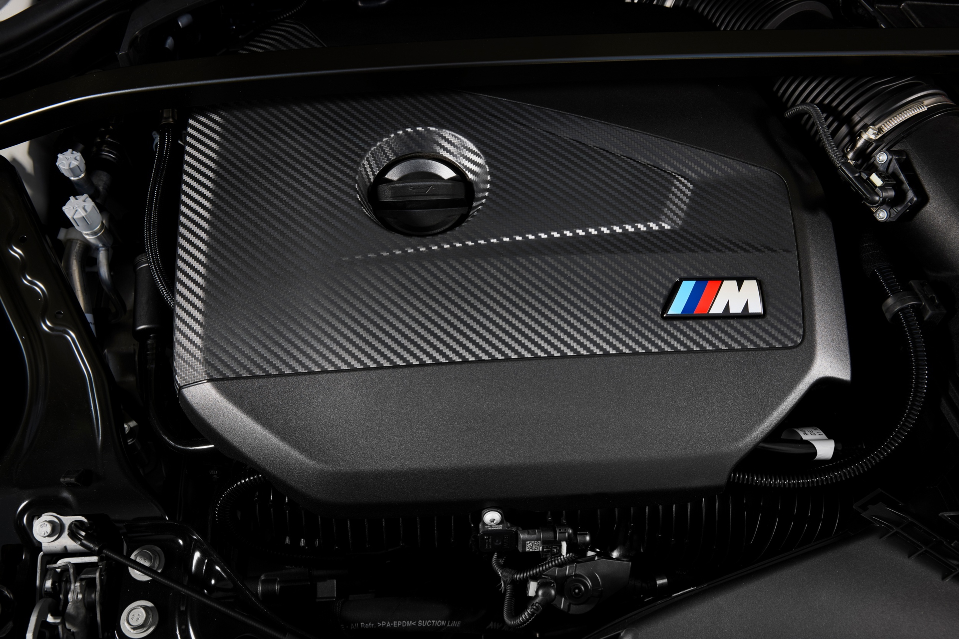 Vista del propulsor BMW M135, detalle en carbono y distintivo M.