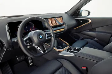 Vista del habitáculo del nuevo BMW X3 mostrando volante y consola central.