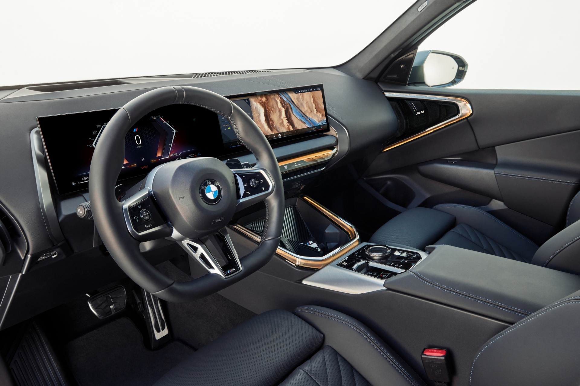 Vista del habitáculo del nuevo BMW X3 mostrando volante y consola central.