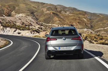 Vista dinámica del BMW X3 20xd en carretera serpenteante.