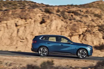 El BMW X3 30e xDrive presenta su elegante línea lateral en un entorno natural.