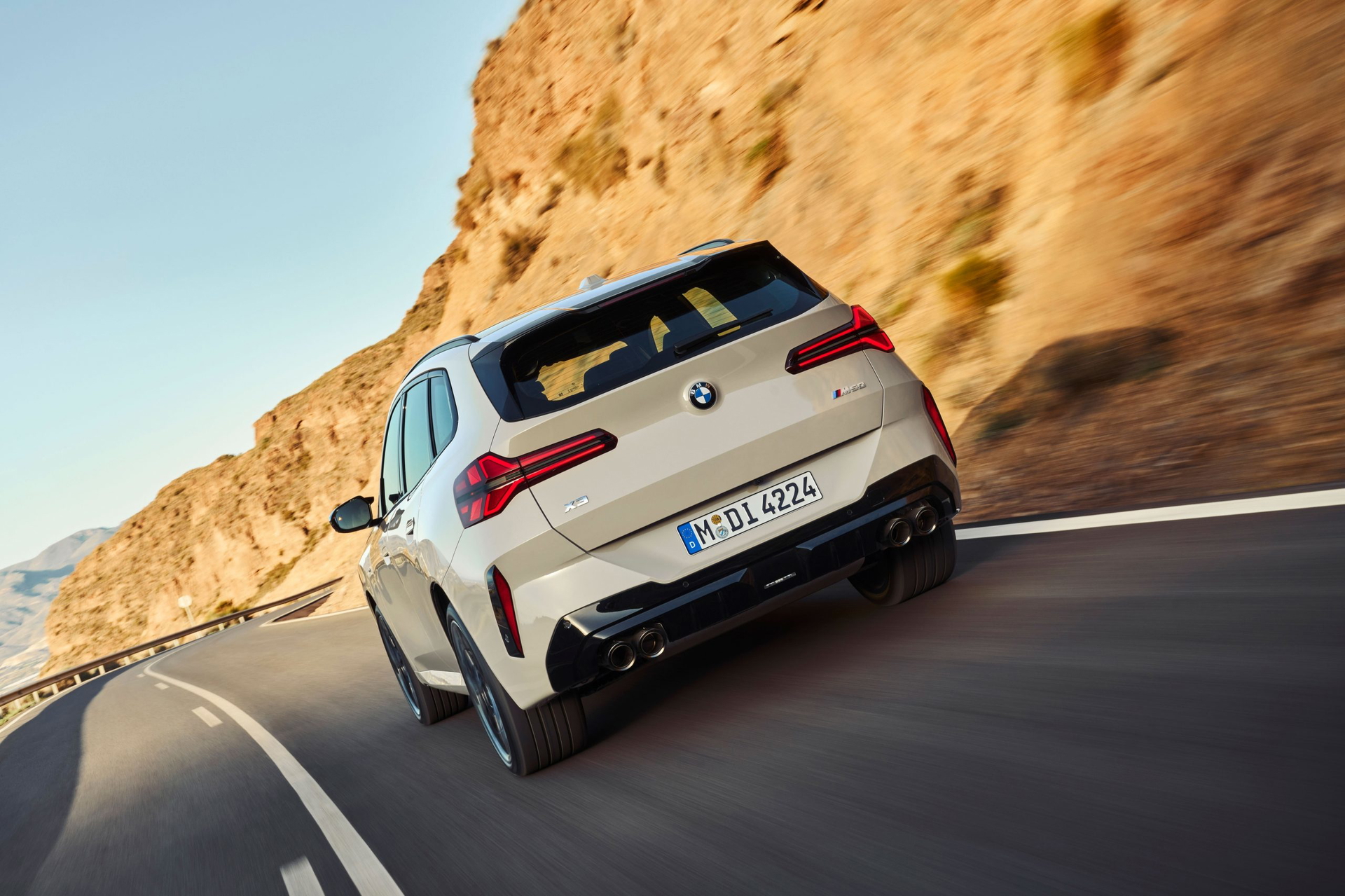 Trasera del BMW X3 M50i en acción, destacando su dinamismo y línea deportiva.