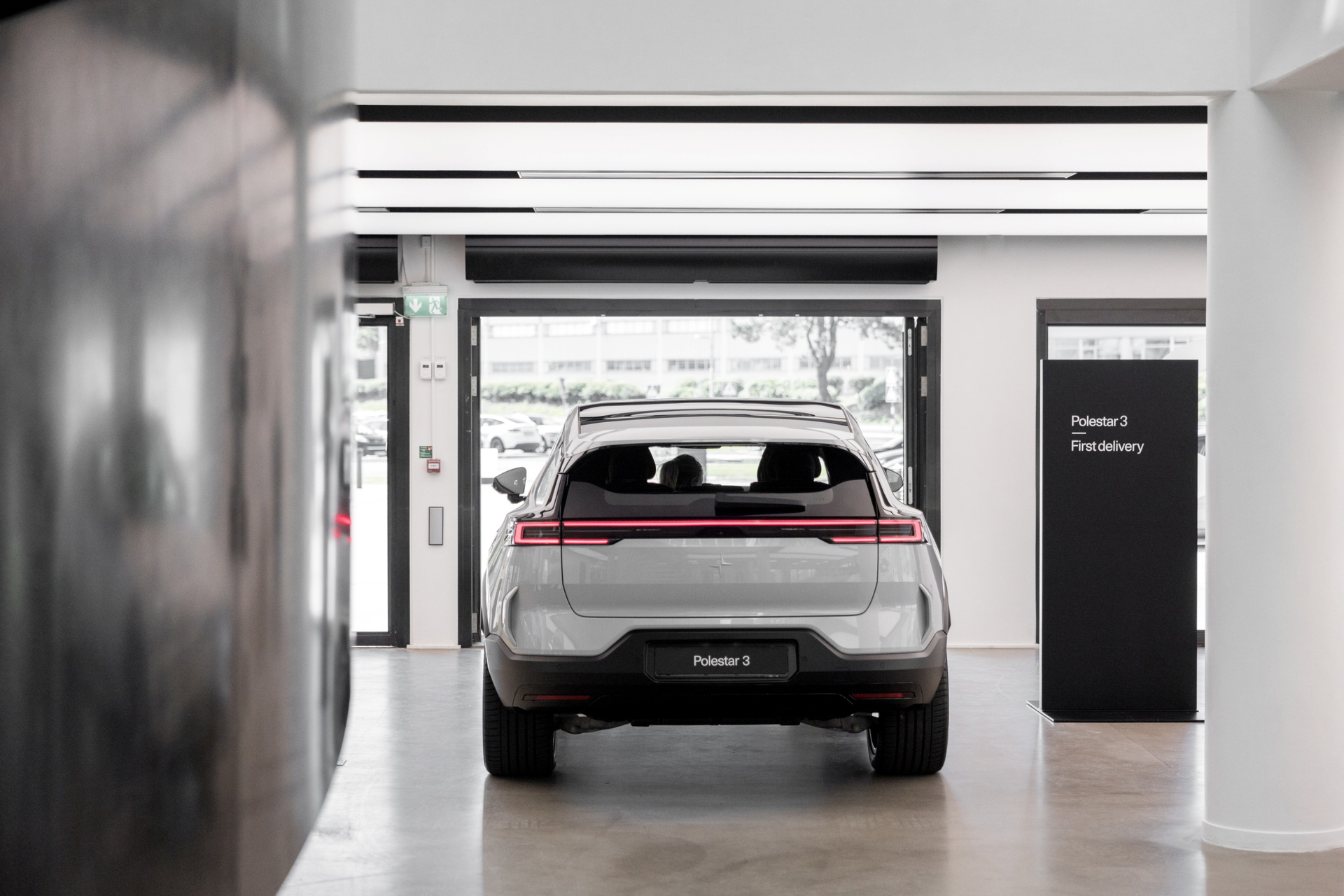 Vista trasera del Polestar 3 EV mientras es entregado en la sala de exposición