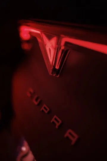 Vista detallada del icónico emblema iluminado de CUPRA en rojo.
