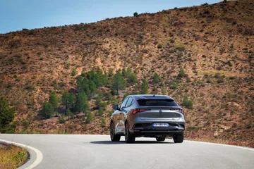 Vista dinámica del Renault Rafale 2024 en carretera, destacando su diseño coupé