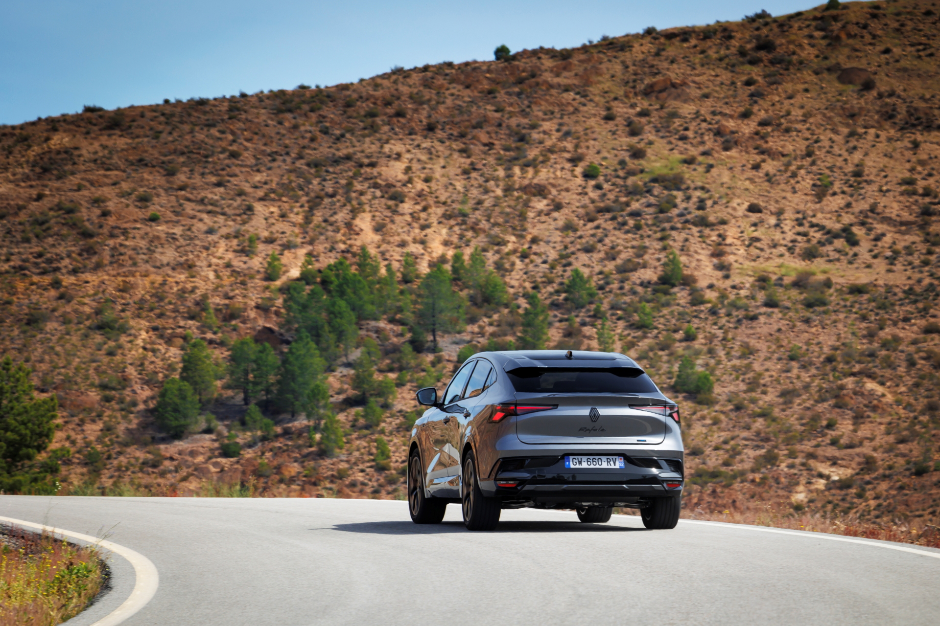 Vista dinámica del Renault Rafale 2024 en carretera, destacando su diseño coupé