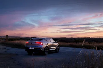Vista trasera y lateral del Renault Rafale 2024 al atardecer, elegancia y deportividad.