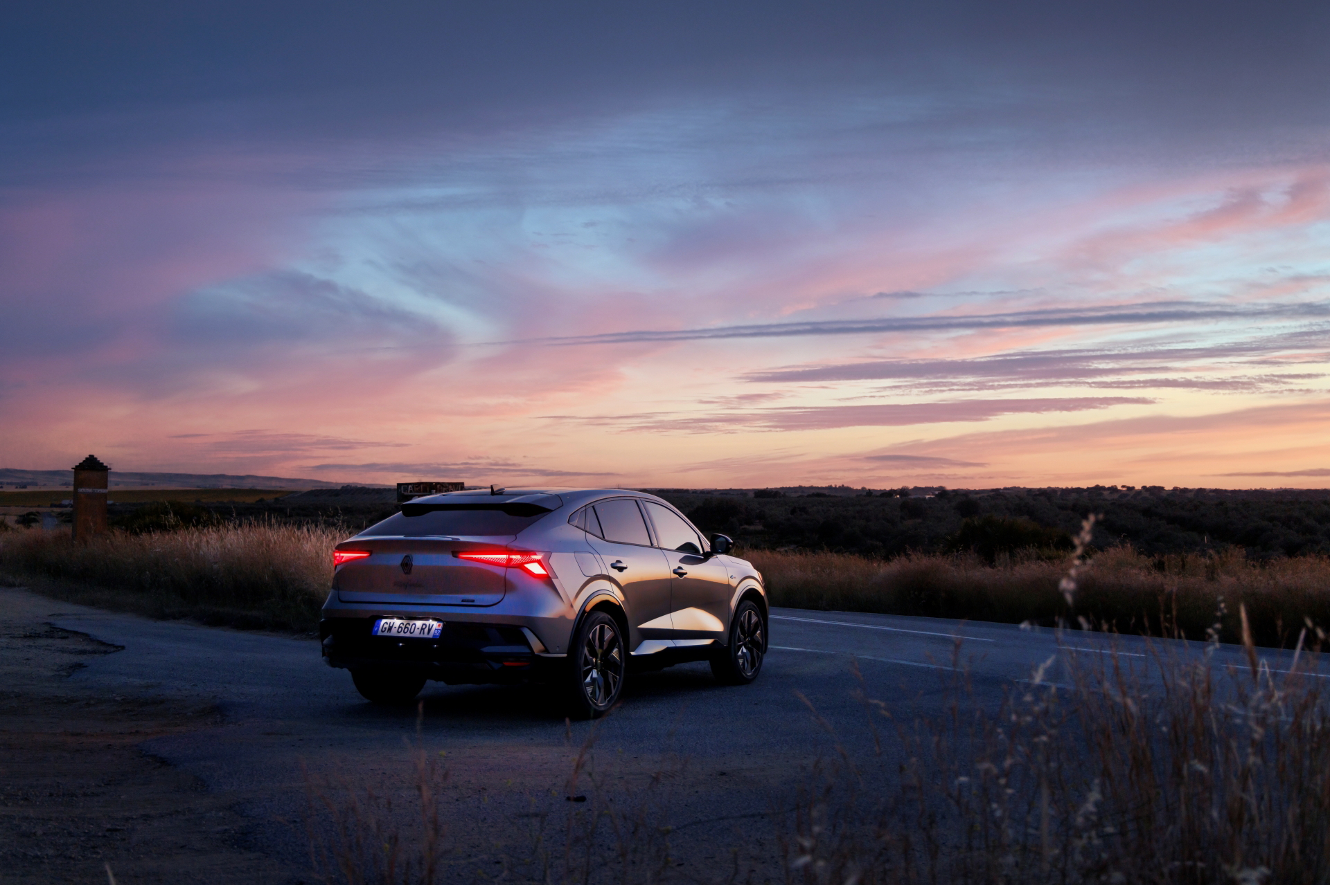 Vista trasera y lateral del Renault Rafale 2024 al atardecer, elegancia y deportividad.
