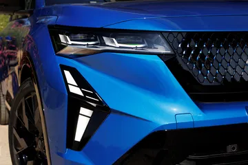 Vista parcial frontal del Renault Rafale 2024, destacando luces y parrilla.