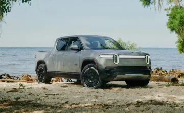A side view of the Rivian R1T, reflecting its off-road capability and rugged design. A side view of the Rivian R1T, reflecting its off-road capability and rugged design.