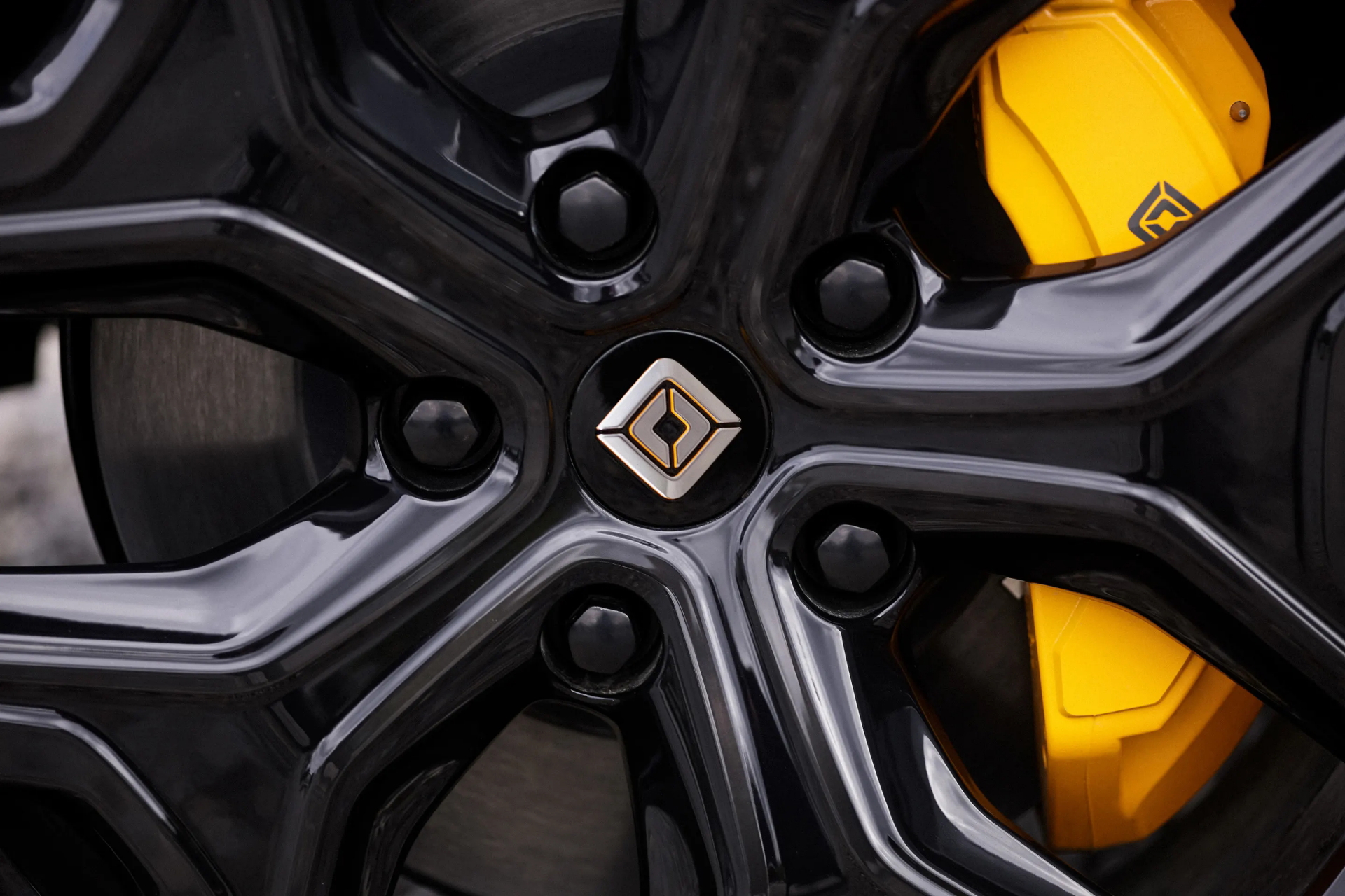 Vista cercana del disco de freno y caliper amarillo de Rivian R1T, simbolizando potencia y rendimiento.