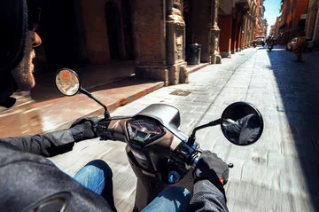Vista en primera persona de la scooter retro de 300 cc navegando por la ciudad
