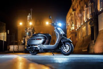 Elegante scooter retro 300 cc iluminada en entorno urbano nocturno