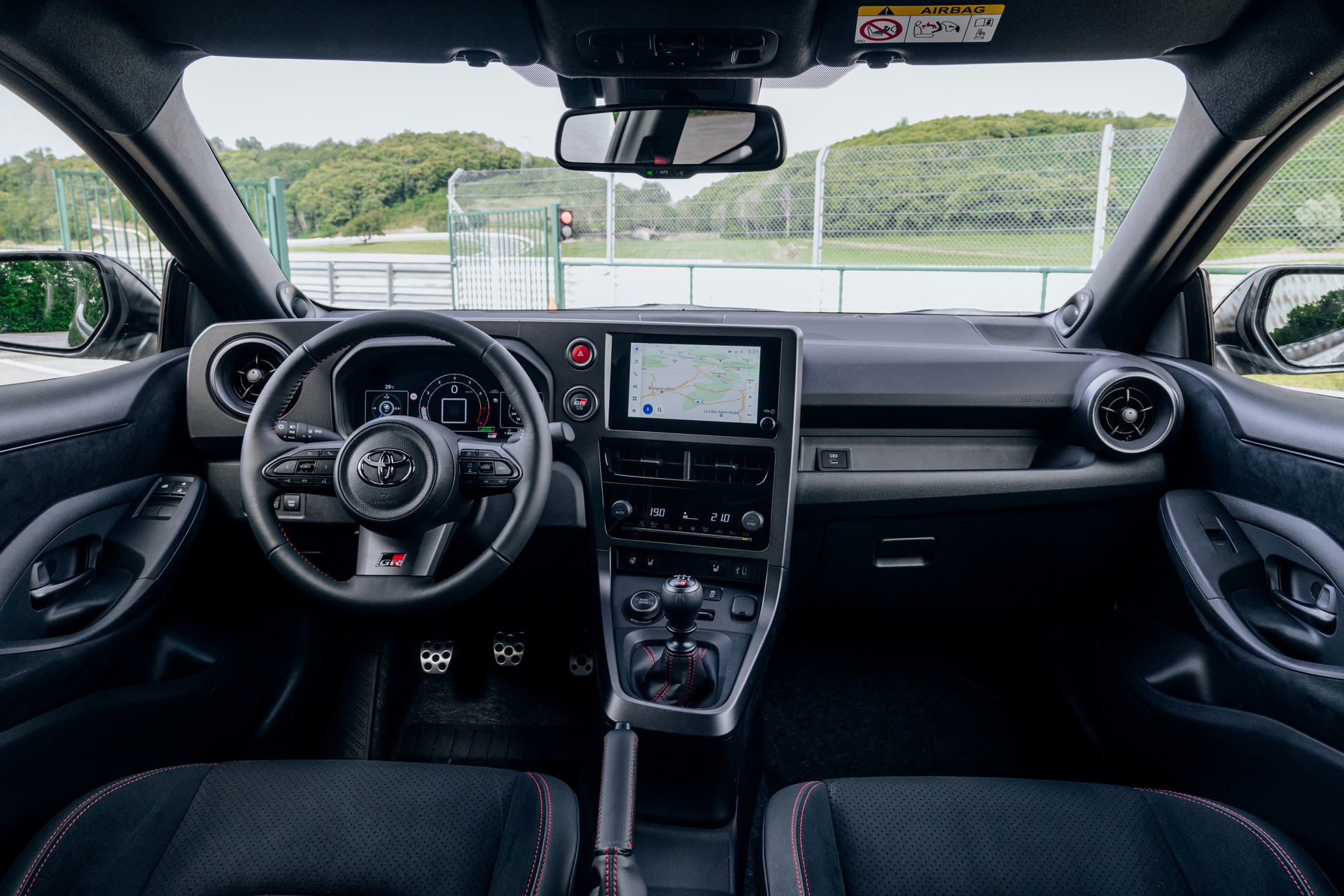 Vista delantera del habitáculo del Toyota GR Yaris, destacando su diseño enfocado al conductor.