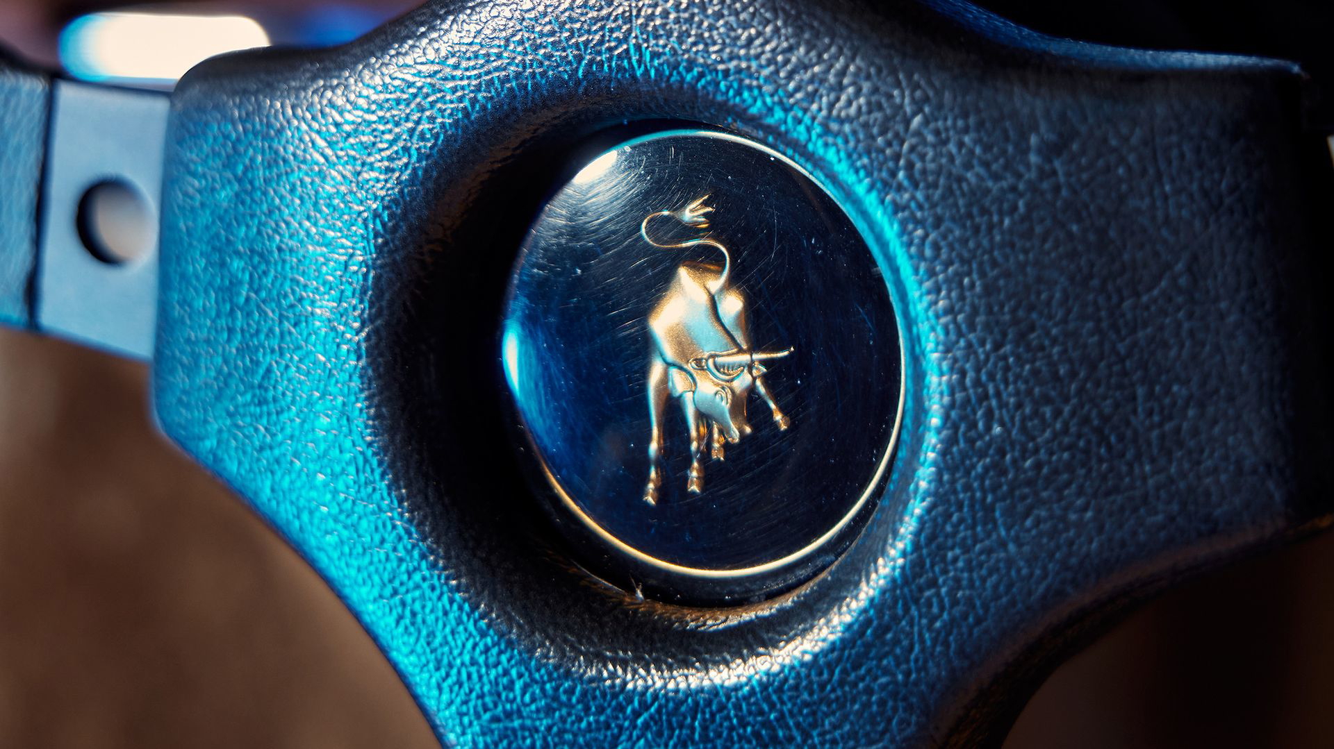 Primer plano del emblema de Lamborghini en el volante.