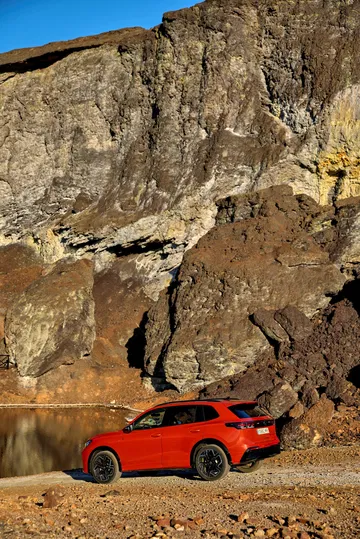 Vista lateral del Volkswagen Tiguan 2024 en un entorno natural rocoso