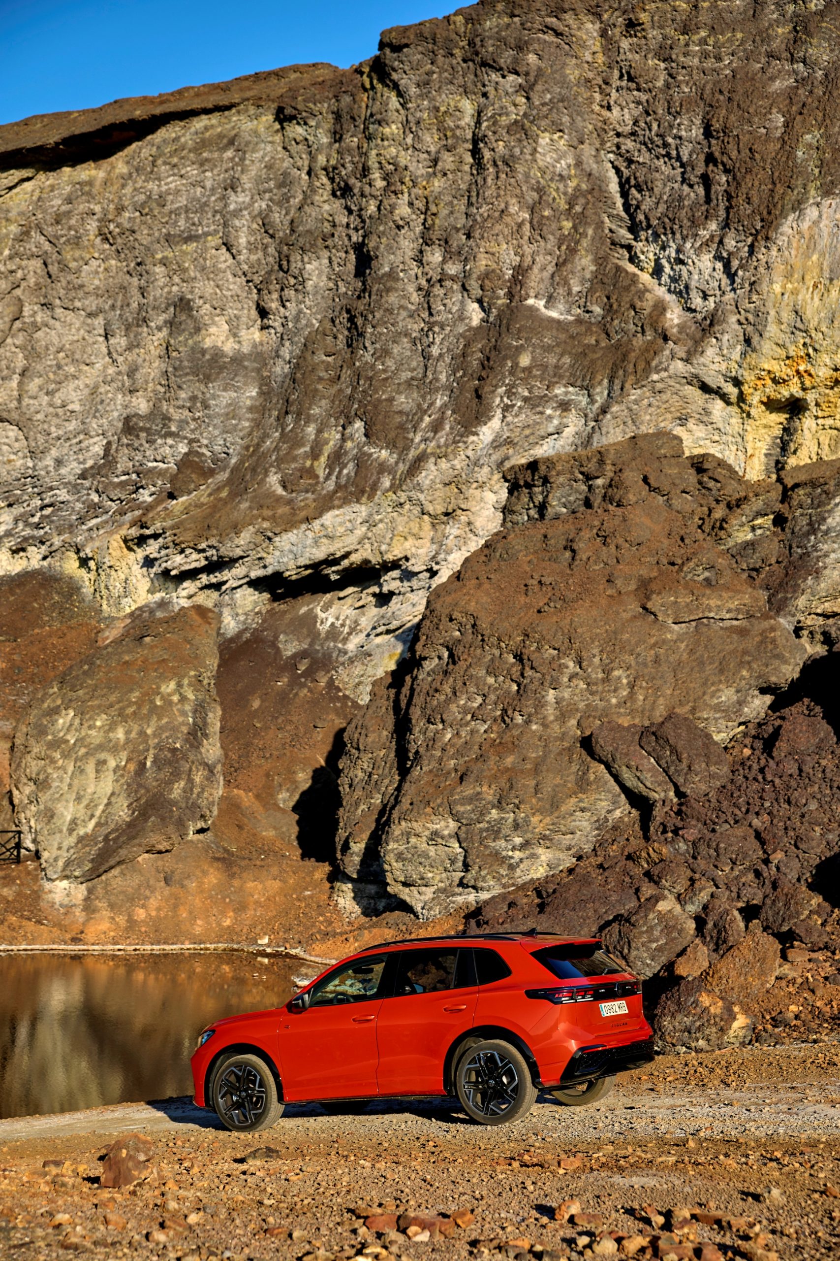 Vista lateral del Volkswagen Tiguan 2024 en un entorno natural rocoso