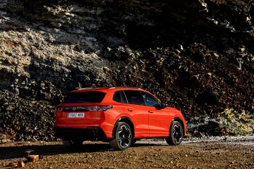 Vista lateral y trasera del Volkswagen Tiguan 2024 en ambiente natural.