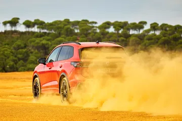 Vista dinámica del Volkswagen Tiguan 2024 en terreno arenoso.