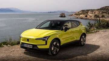 Volvo eléctrico amarillo destacando su diseño sueco en un paisaje costero.