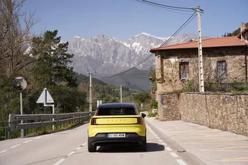Compacto eléctrico premium en ruta, mostrando su capacidad de viaje por entornos rurales.