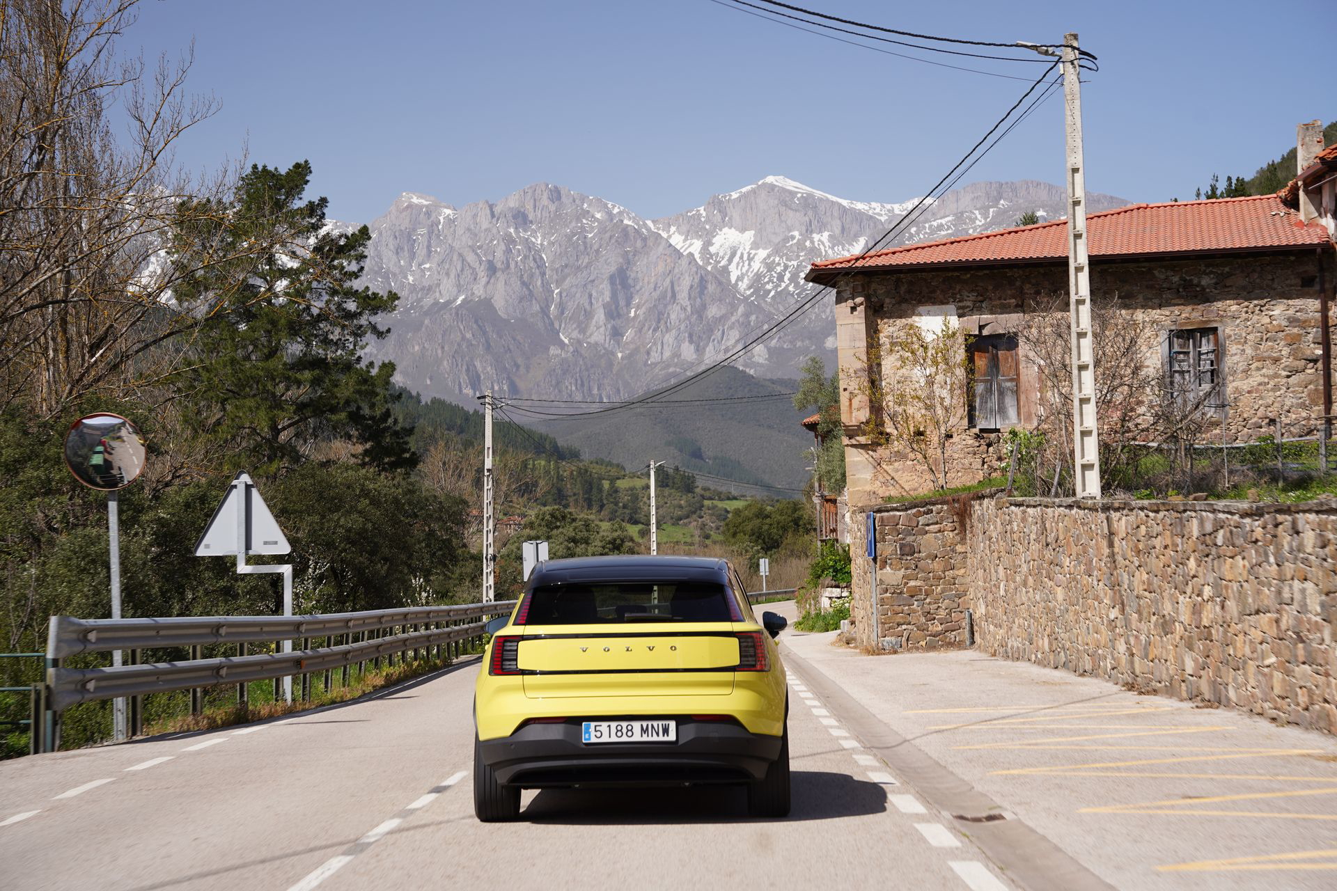 Compacto eléctrico premium en ruta, mostrando su capacidad de viaje por entornos rurales.