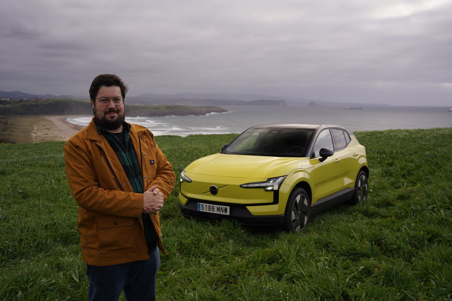 El Volvo EX30 amarillo luce su diseño lateral en terreno abierto