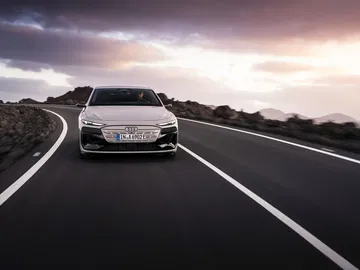 Vista dinámica frontal del Audi A6 e-tron en carretera, destacando su diseño vanguardista.