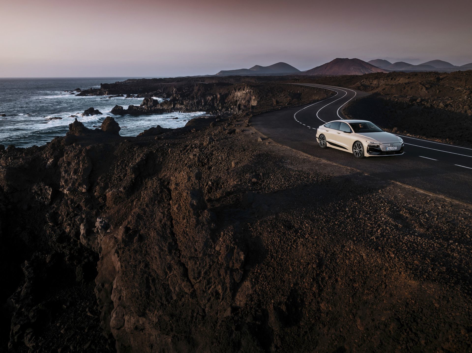 Audi A6 e-tron 2024 capturado en un entorno natural, mostrando su perfil elegante y moderno.